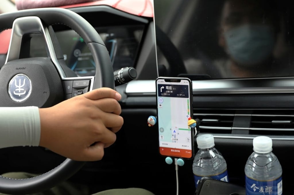 A driver of Chinese ride-hailing service Didi drives with a phone showing a navigation map on Didi's app in Beijing on July 5, 2021. Photo: Reuters