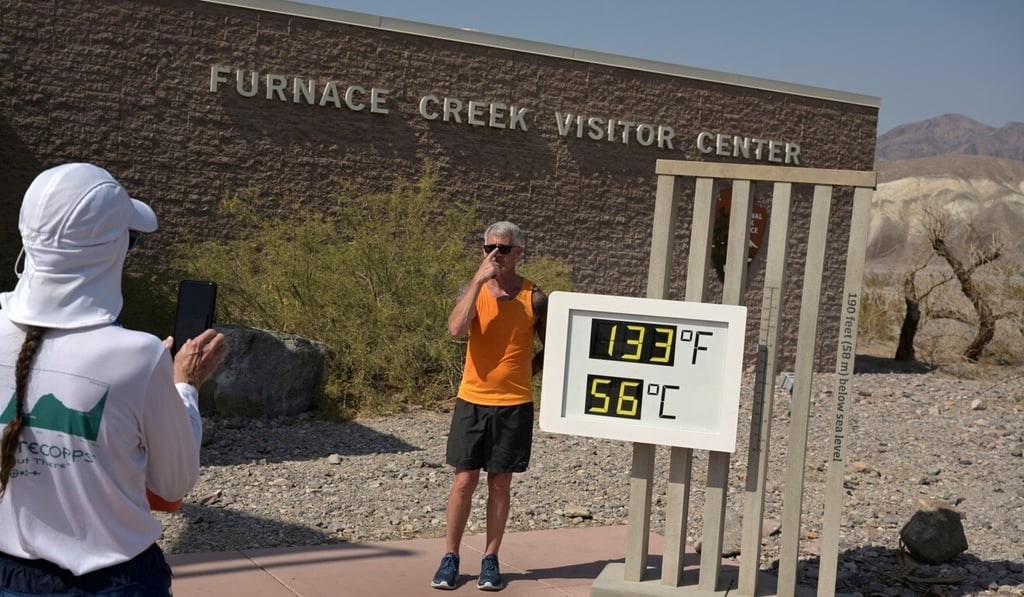 A person poses for a photo next to a thermometer in Death Valley, California. Photo: Reuters A person poses for a photo next to a thermometer in Death Valley, California. Photo: Reuters
