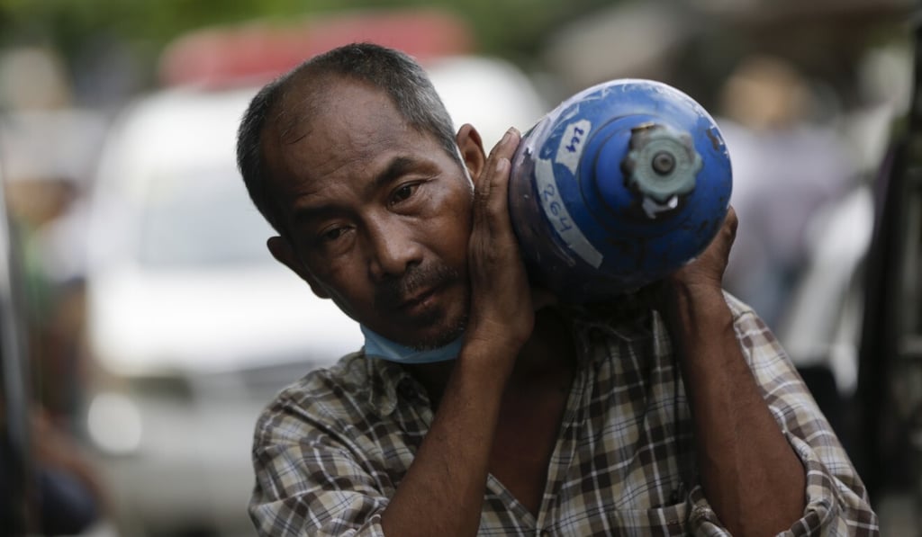 A Yangon resident collects a cylinder of medical oxygen from a factory. Photo: EPA