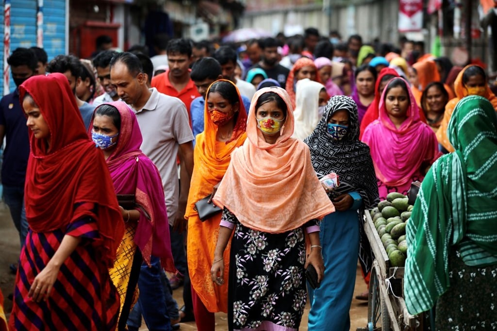 Garment workers come out of a factory during the lunch break as factories remain open despite a countrywide lockdown, in Dhaka, Bangladesh. Photo: Reuters