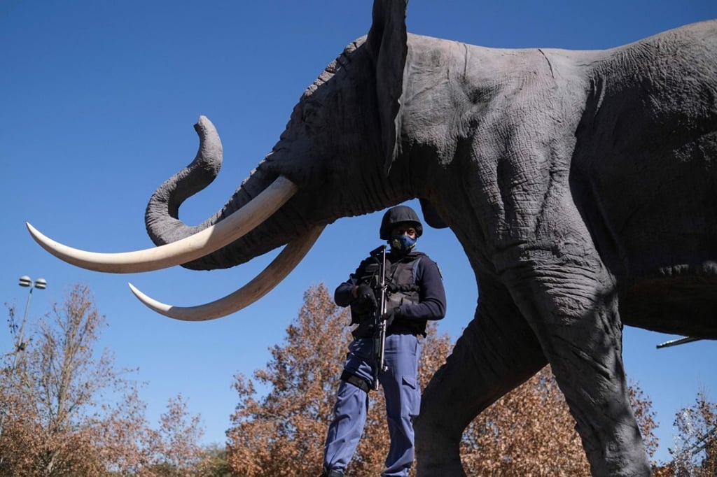 A South African Police Service (SAPS) officer stands guard at the Maponya mall in Soweto on Sunday. Photo: AFP