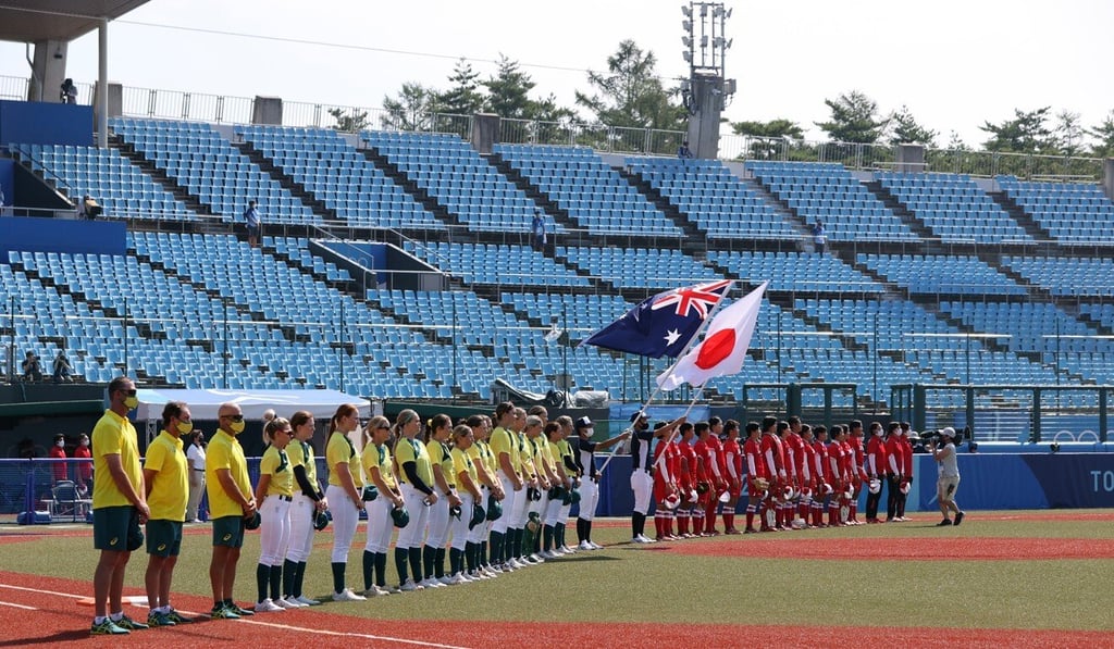 Team Japan and Team Australia players stand during national anthems ahead of the opening game of the softball. Photo: EPA