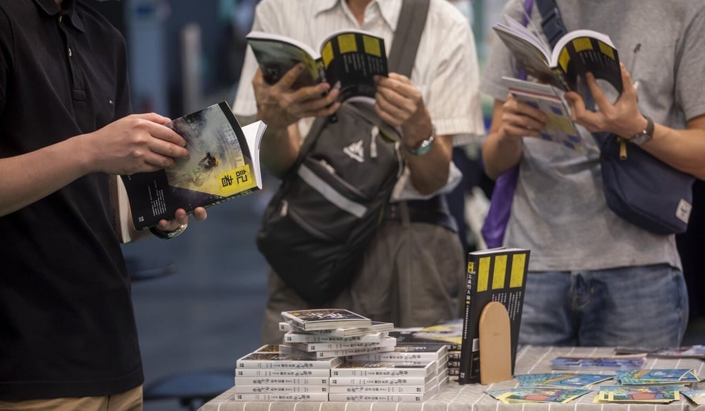 Visitors at the Hong Kong Book Fair read copies of a book documenting the experiences of journalists covering the 2019 protests. Photo: Bloomberg Visitors at the Hong Kong Book Fair read copies of a book documenting the experiences of journalists covering the 2019 protests. Photo: Bloomberg