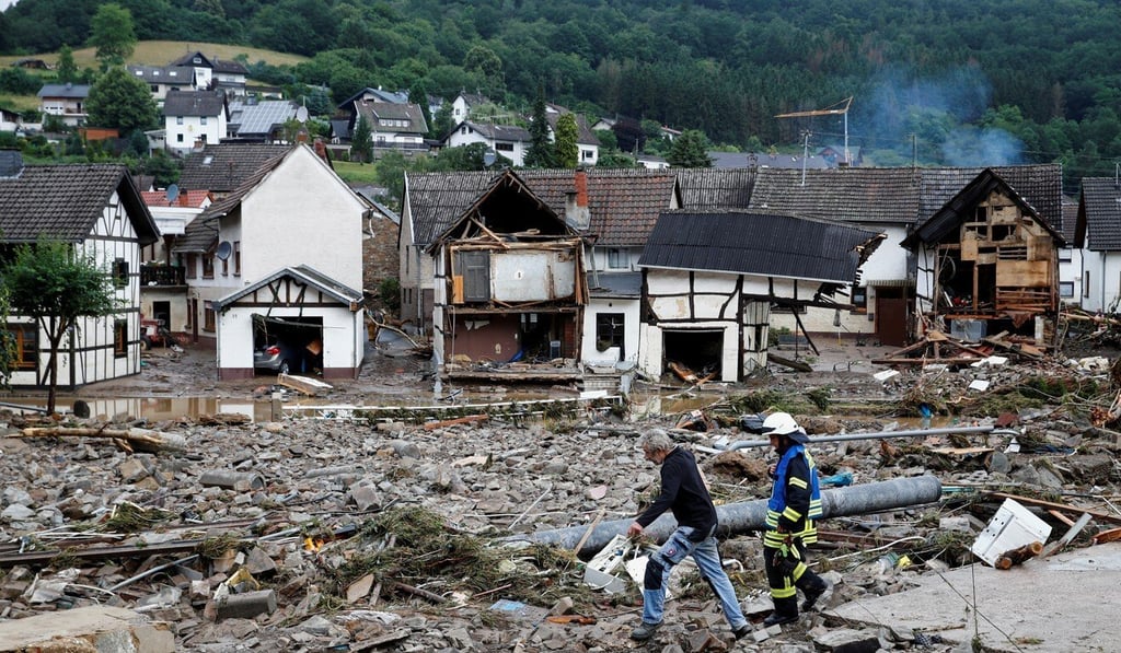 A man and firefighter walk through debris, following heavy rainfalls in Schuld, Germany. Photo: Reuters A man and firefighter walk through debris, following heavy rainfalls in Schuld, Germany. Photo: Reuters