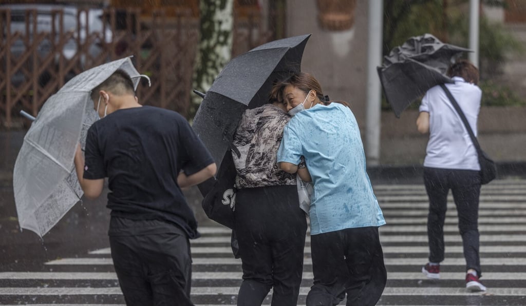 People in Shanghai use their umbrellas to brace against strong winds caused by Typhoon In-fa. Photo: EPA-EFE People in Shanghai use their umbrellas to brace against strong winds caused by Typhoon In-fa. Photo: EPA-EFE