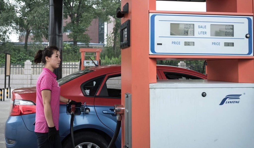 A petrol pump attendant fills up a taxi in Pyongyang. Photo: AFP