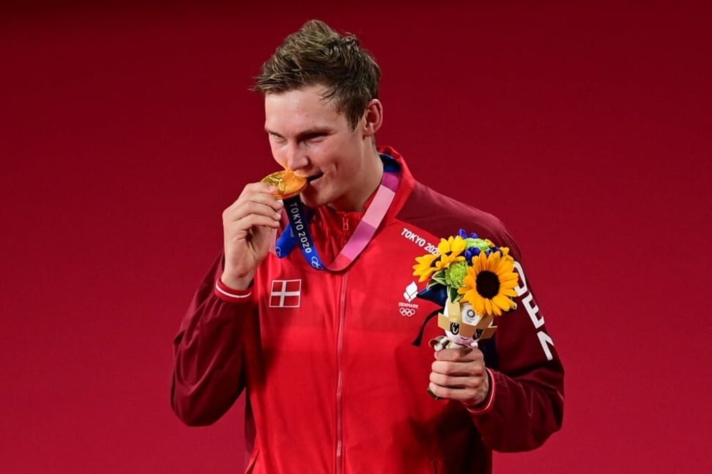 Denmark's Viktor Axelsen bites his gold medal. Photo: AFP Denmark's Viktor Axelsen bites his gold medal. Photo: AFP