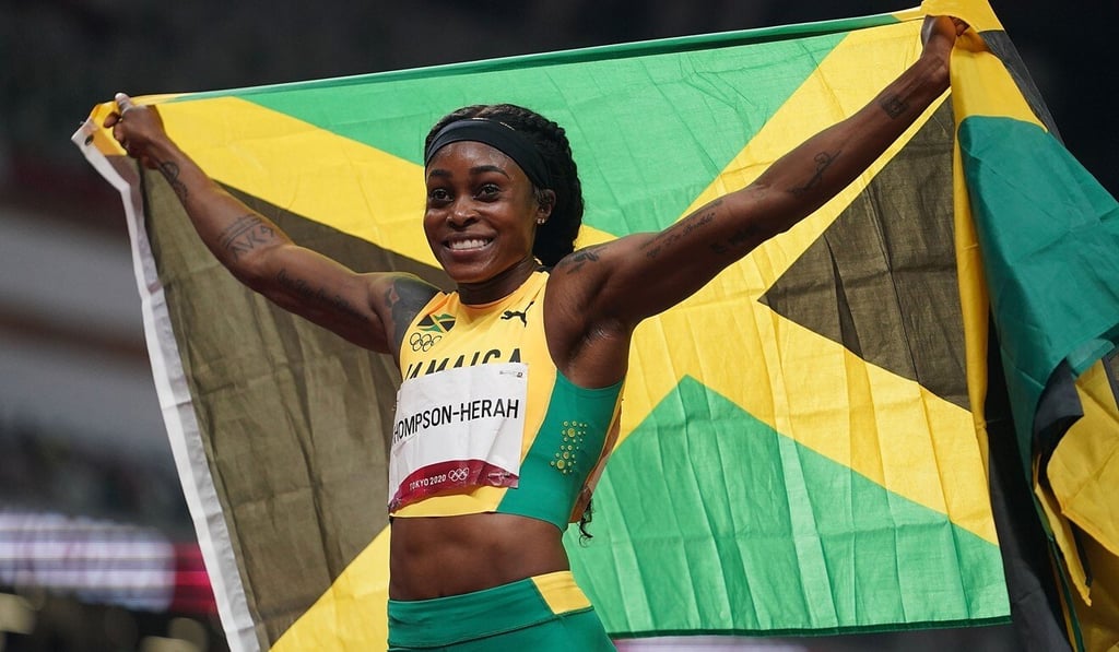 Jamaica’s Elaine Thompson-Herah raises her country’s flag after winning the women’s 200m final. Photo: Xinhua Jamaica’s Elaine Thompson-Herah raises her country’s flag after winning the women’s 200m final. Photo: Xinhua