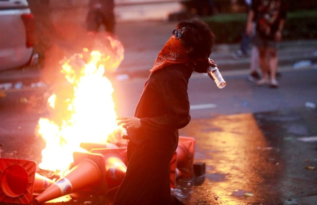 A demonstrator clashes with police officers in Bangkok. Photo: Reuters A demonstrator clashes with police officers in Bangkok. Photo: Reuters