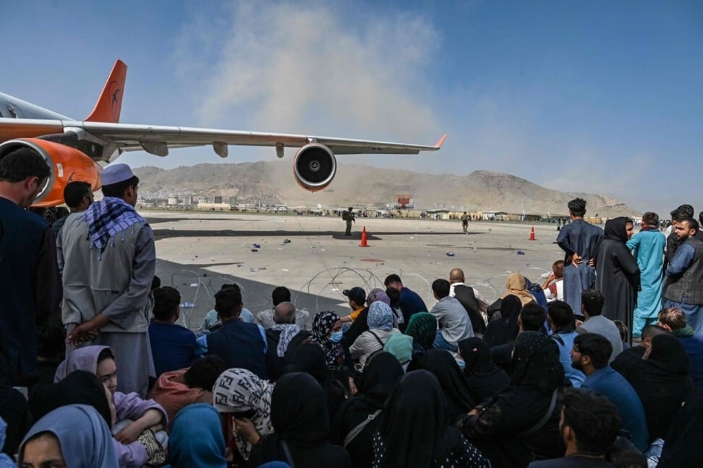 Afghan people wait to leave the Kabul airport on August 16, 2021. Photo: AFP