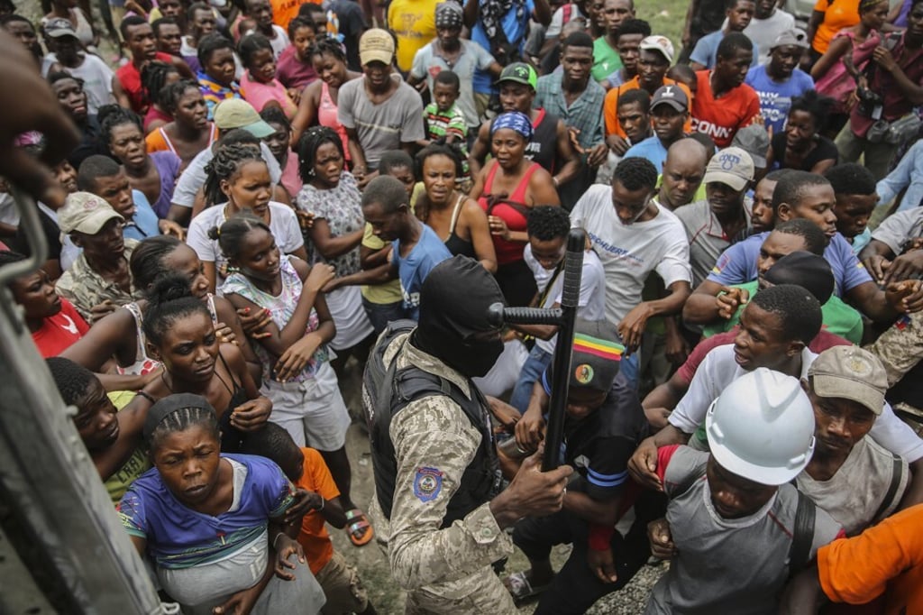 Earthquake victims scramble for a handout of rice at a food distribution place in Les Cayes, Haiti on Monday. Photo: AP