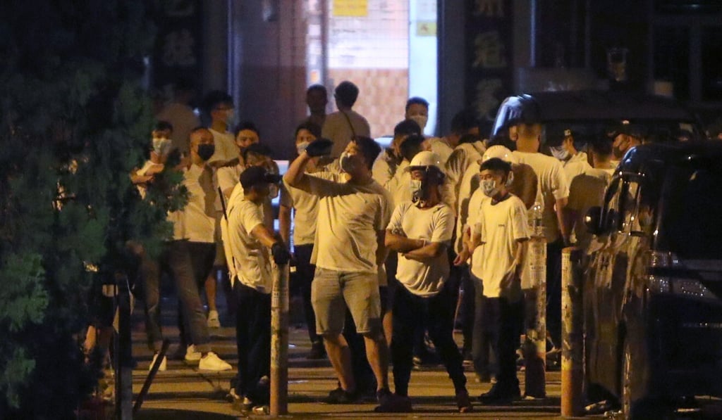 Men in white T-shirts stand on the streets of Yuen Long after protesters and commuters were attacked on July 21, 2019. Photo: Winson Wong Men in white T-shirts stand on the streets of Yuen Long after protesters and commuters were attacked on July 21, 2019. Photo: Winson Wong