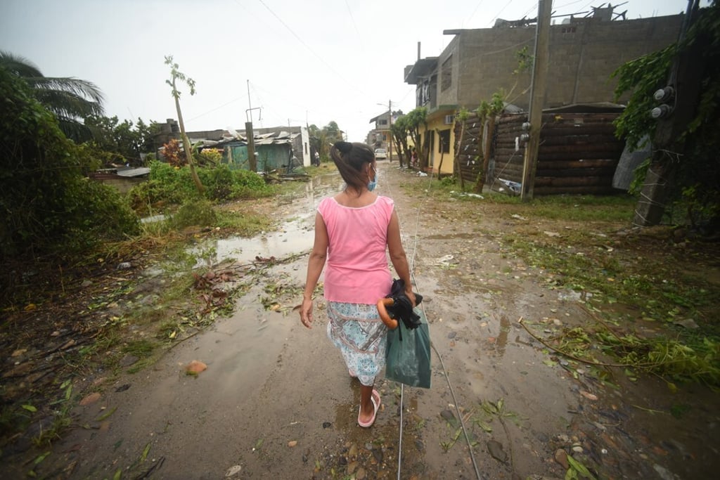 A resident walks past debris on a street in Tecolitla. Photo: Bloomberg A resident walks past debris on a street in Tecolitla. Photo: Bloomberg