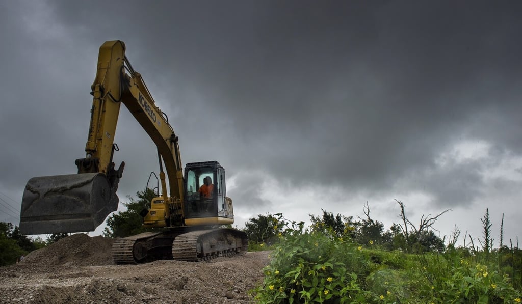 Road crews shore up levees and vulnerable roadways with gravel in New Orleans. Photo: The Times-Picayune/The New Orleans Advocate via AP Road crews shore up levees and vulnerable roadways with gravel in New Orleans. Photo: The Times-Picayune/The New Orleans Advocate via AP