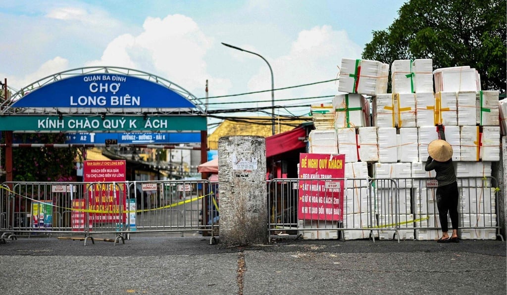 A woman pushes empty styrofoam boxes used to create an improvised barricade outside a wholesale market in Hanoi. Photo: AFP