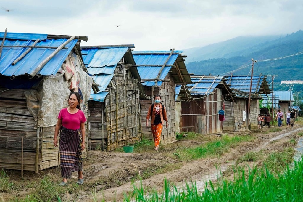 People walk past makeshift structures constructed along the Myanmar-China border after residents from Muse township fled their villages due to fighting between the military and ethnic armed groups. Photo: AFP