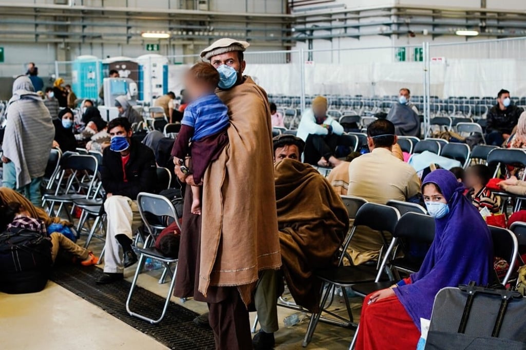 People evacuated from Afghanistan waiting in a hangar at Ramstein Air Base in Germany that the US military is using as a hub to process refugees for onward transport to the United States. Photo: DPA