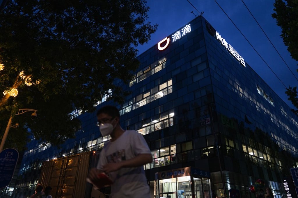 A pedestrian passes Didi Chuxing’s headquarters at night in Beijing on July 5, 2021. Photo: Bloomberg