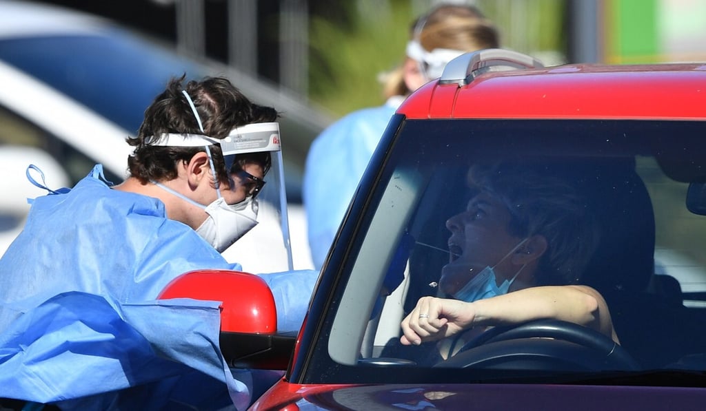 Health care workers collect swab samples from people at a pop-up Covid-19 testing centre in Brisbane. Photo: EPA