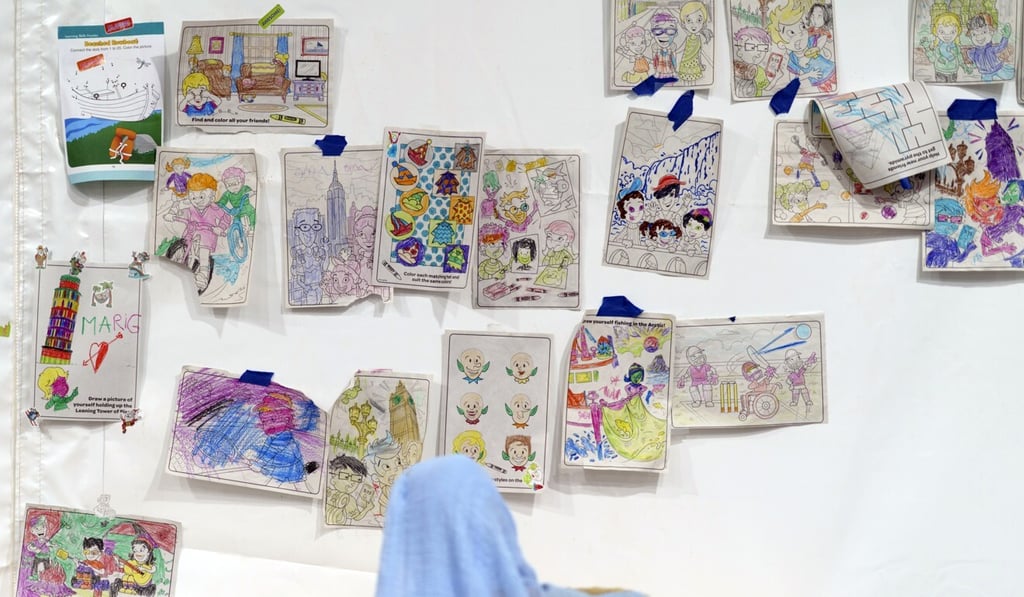 A child looks at artwork made by kids in a tent at the Doña Ana Village in Fort Bliss, where Afghan refugees are being housed. Photo: AP
