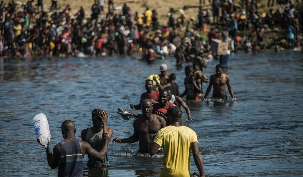Migrants wade across the Rio Grande from Del Rio, Texas, to Ciudad Acuna, Mexico, to shop for food and supplies before returning back to the US side of the border. Photo: AP Migrants wade across the Rio Grande from Del Rio, Texas, to Ciudad Acuna, Mexico, to shop for food and supplies before returning back to the US side of the border. Photo: AP