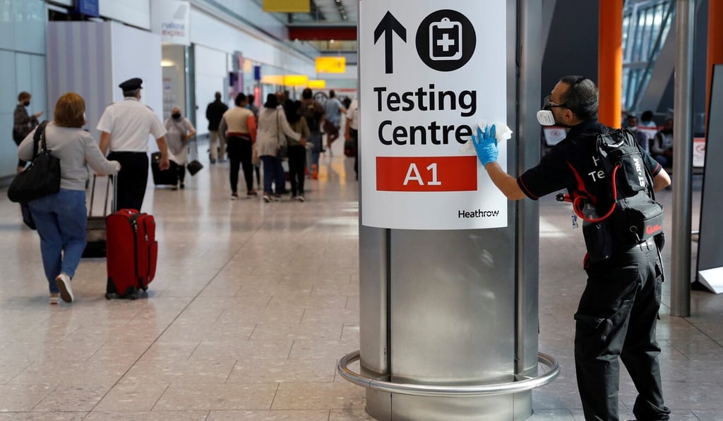 A worker sanitises a sign at the international arrivals area of London's Heathrow Airport last month. Photo: Reuters