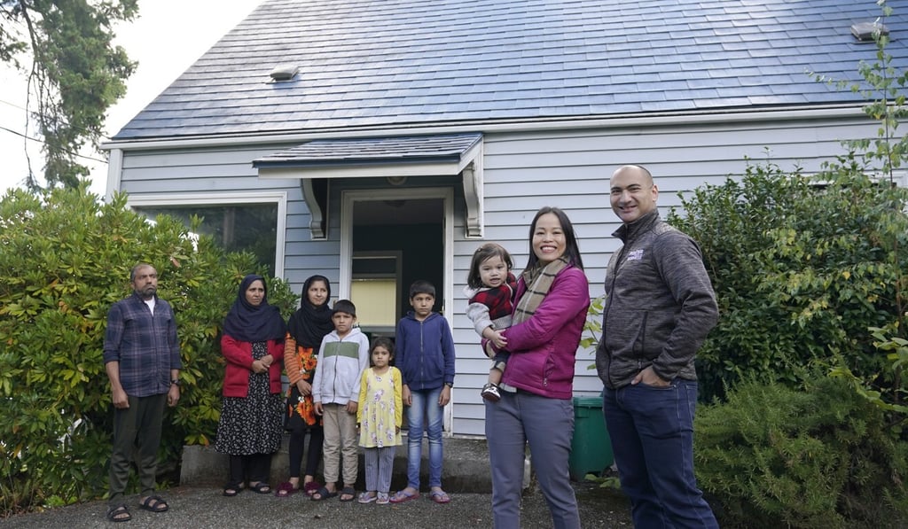 Thuy Do and her husband Jesse Robbins, right, pose with an Afghan family in Seattle. Photo: AP