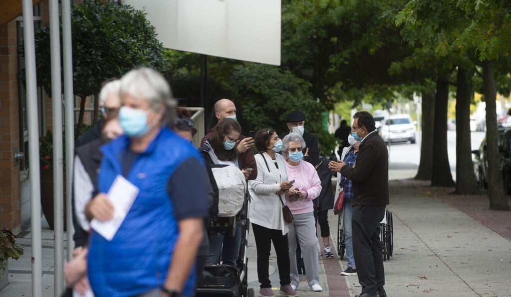Voters wait in line outside a polling station in North Vancouver, British Columbia, on Monday. Photo: Bloomberg