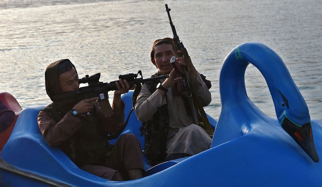 Taliban fighters ride on a paddle boat. Photo: AFP