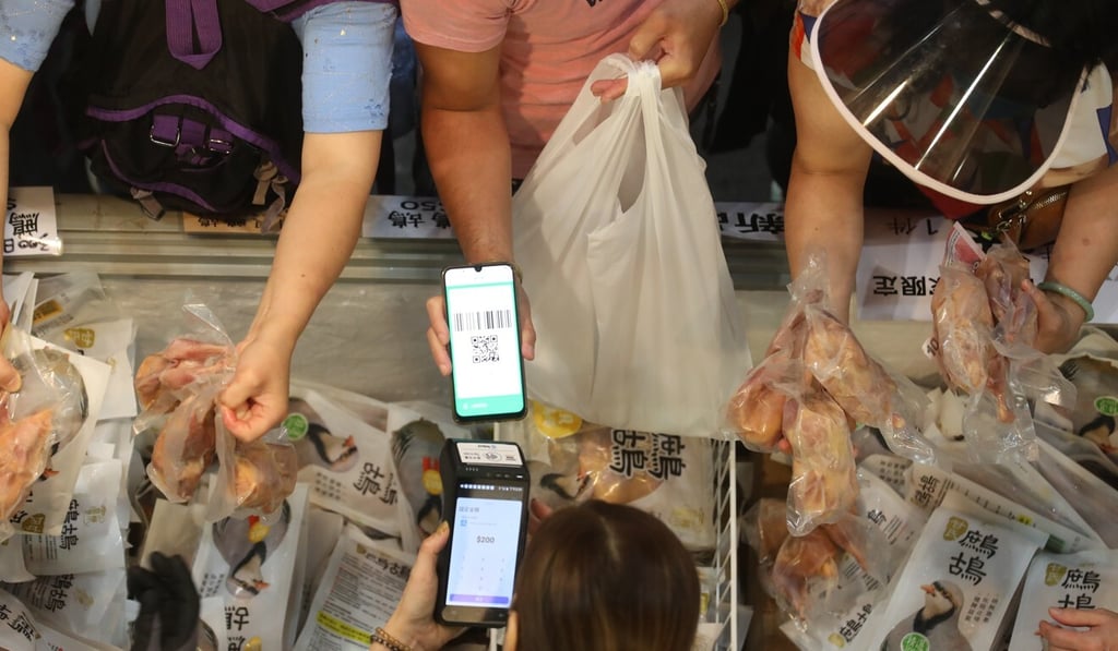 Buyers using their e-vouchers to purchase meat at a market. Photo: Winson Wong Buyers using their e-vouchers to purchase meat at a market. Photo: Winson Wong