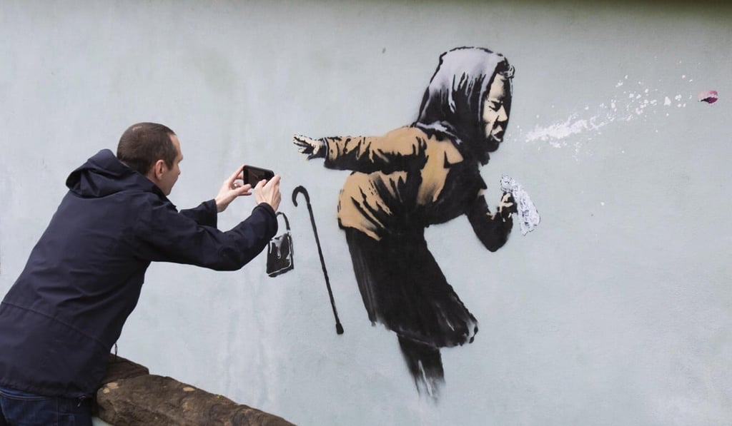 Locals gather to see Banksy’s new creation, Aachoo!!, which appeared on Vale Street overnight in Bristol in December. Photo: EPA-EFE Locals gather to see Banksy’s new creation, Aachoo!!, which appeared on Vale Street overnight in Bristol in December. Photo: EPA-EFE