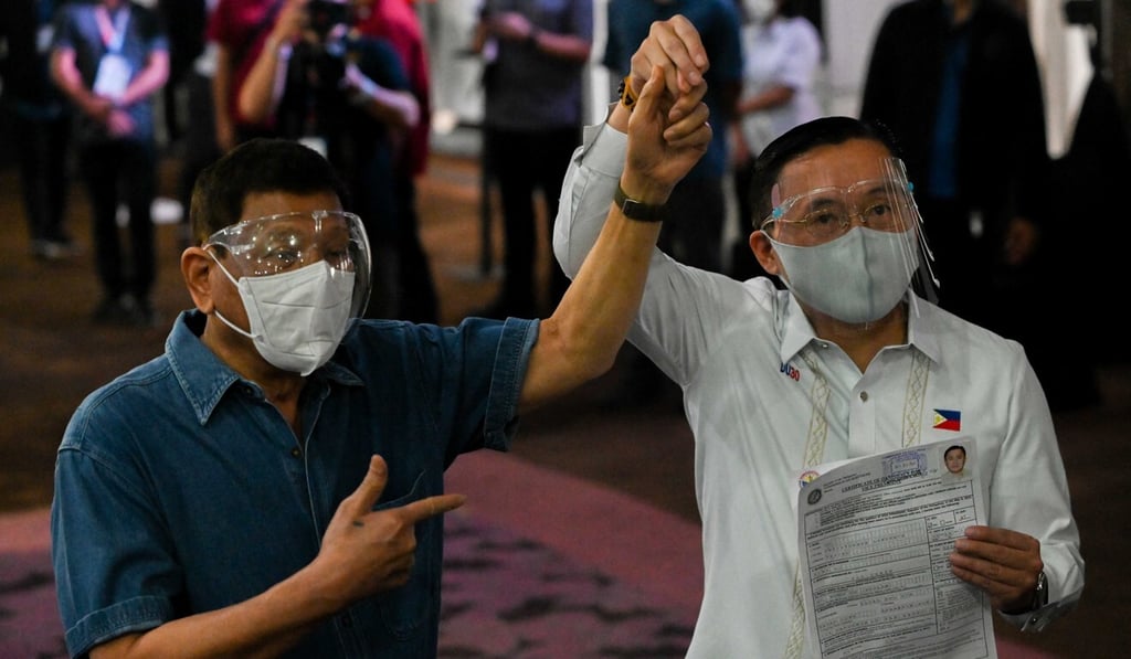 Philippine Senator Christopher ‘Bong’ Go (R), accompanied by Philippine President Rodrigo Duterte, files his certificate of candidacy to run as vice-president on October 2, 2021. Photo: AFP
