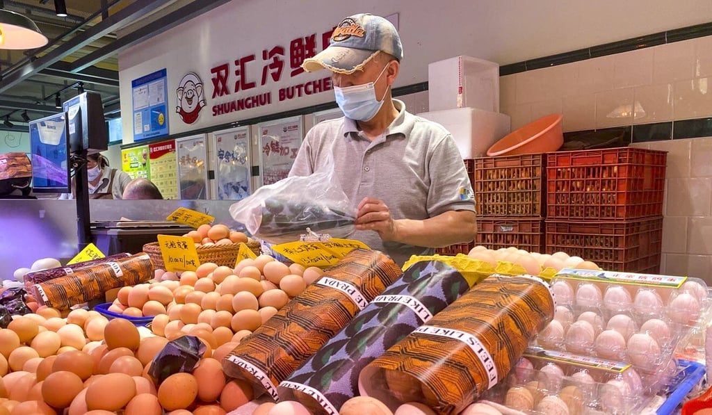 A merchant at Wuzhong wet market in Shanghai sells chicken eggs packaged with Prada wrapping paper. Photo: SCMP/ Daniel Ren