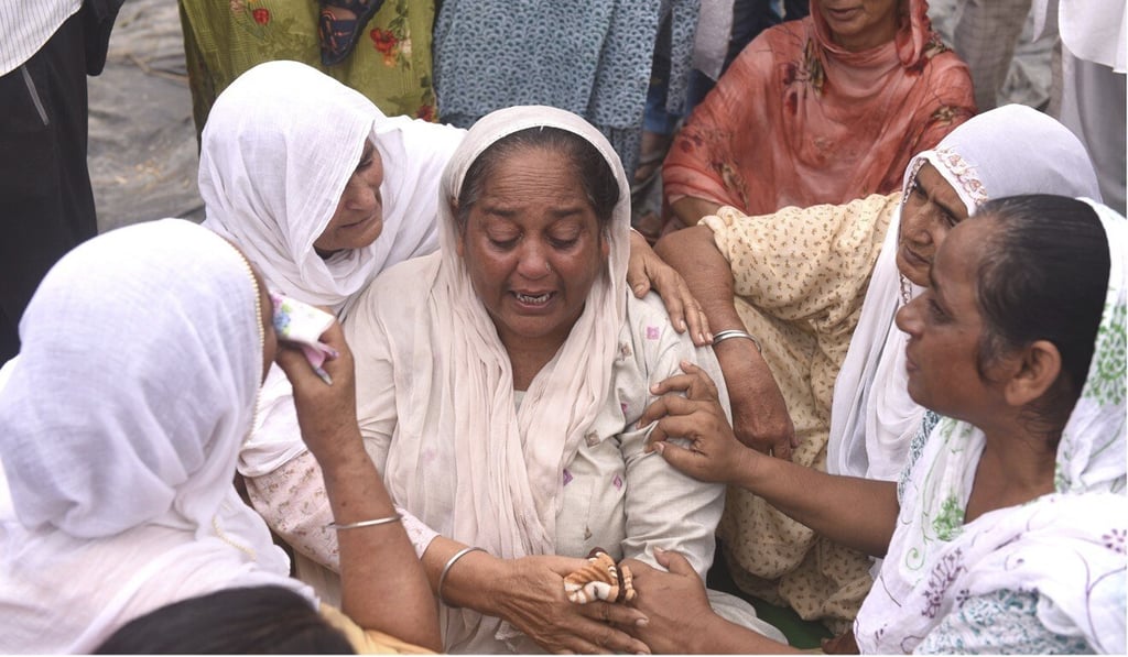 Relatives and neighbours of a farmer who was killed after being run over by a car owned by Junior Home Minister Ajay Mishra last week mourn his death in Lakhimpur Kheri, Uttar Pradesh state. Photo: AP