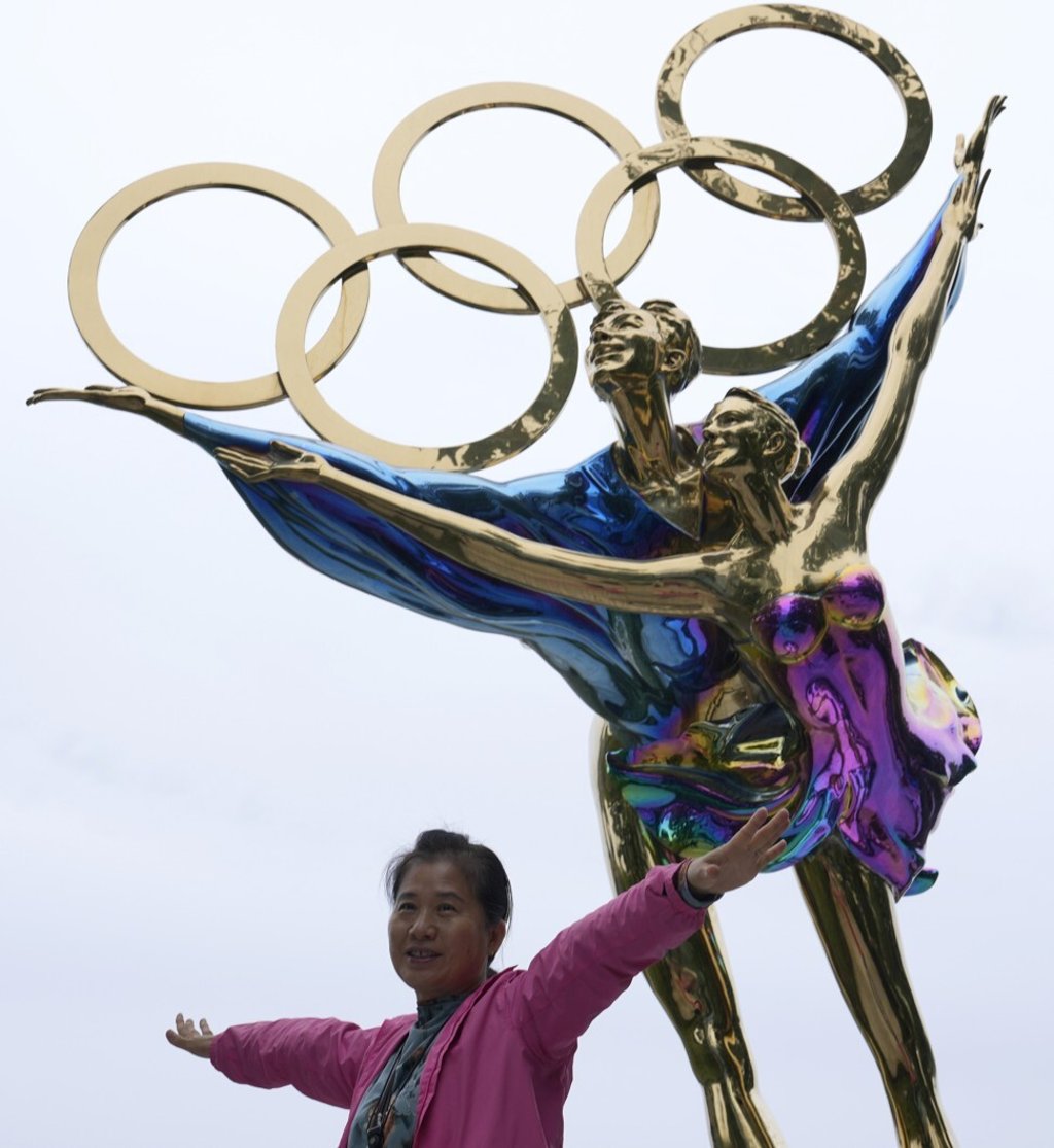 A visitor to the Shougang Park poses for photos in front of a sculpture depicting figure skaters and the Olympic Rings in Beijing. Photo: AP