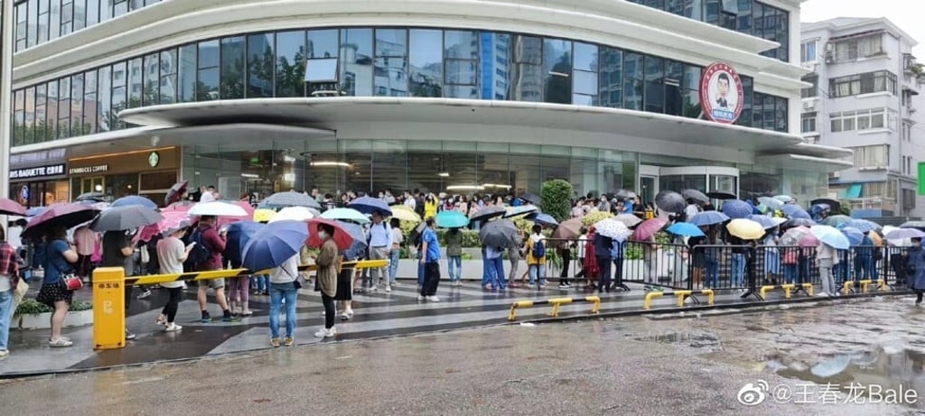 Dozens of parents are seen outside OneSmart International Education Group’s headquarters in Shanghai, as they demanded refunds after the company shut down its tutoring programmes and learning centres across China. Photo: Weibo
