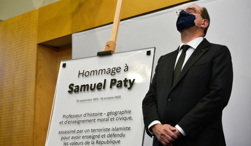 French Prime Minister Jean Castex with a memorial plaque in Paris, one year after teacher Samuel Paty was killed by an extremist. Photo: AFP