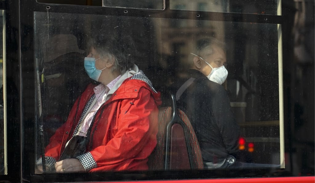 People wear face masks as they sit on a bus in London on Tuesday. Photo: AP
