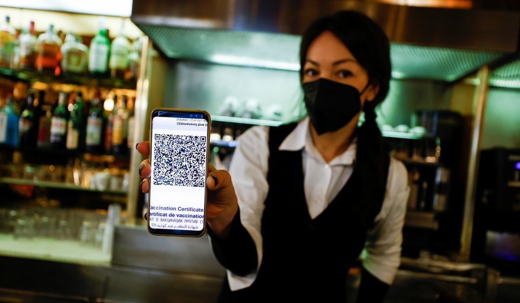 An employee at a cafe shows her Covid-19 ‘Green Pass’. Photo: Reuters An employee at a cafe shows her Covid-19 ‘Green Pass’. Photo: Reuters