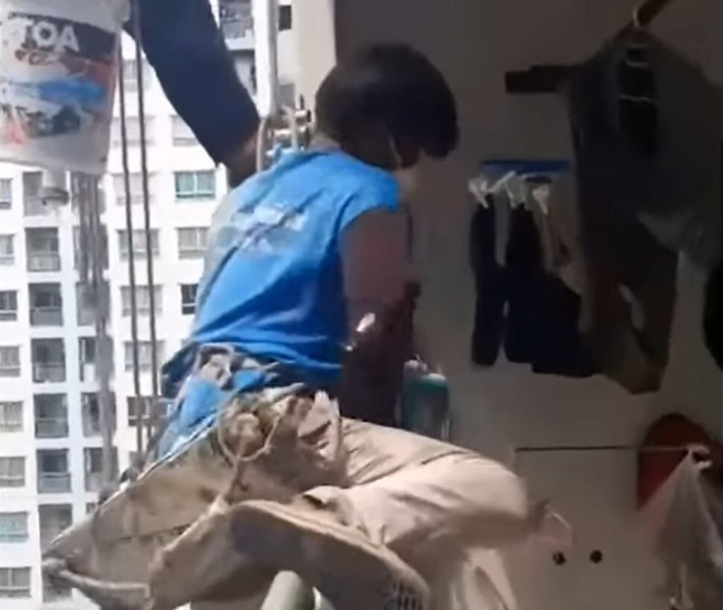 A still from a video that circulated on social media shows the painters clambering onto a balcony on the 26th floor following the incident. Photo: Facebook