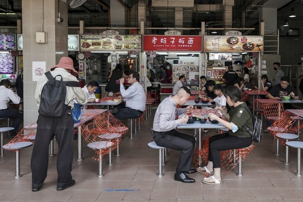 Patrons sit in pairs at cordoned off tables at the Amoy Street Food Centre, in Singapore, in June. Photo: EPA-EFE