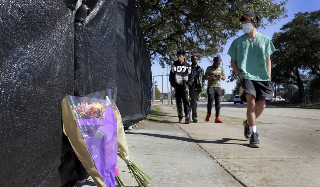 Flowers rest against the fence of festival grounds hours after several people died and scores were injured during a Travis concert in Houston. Photo: AP