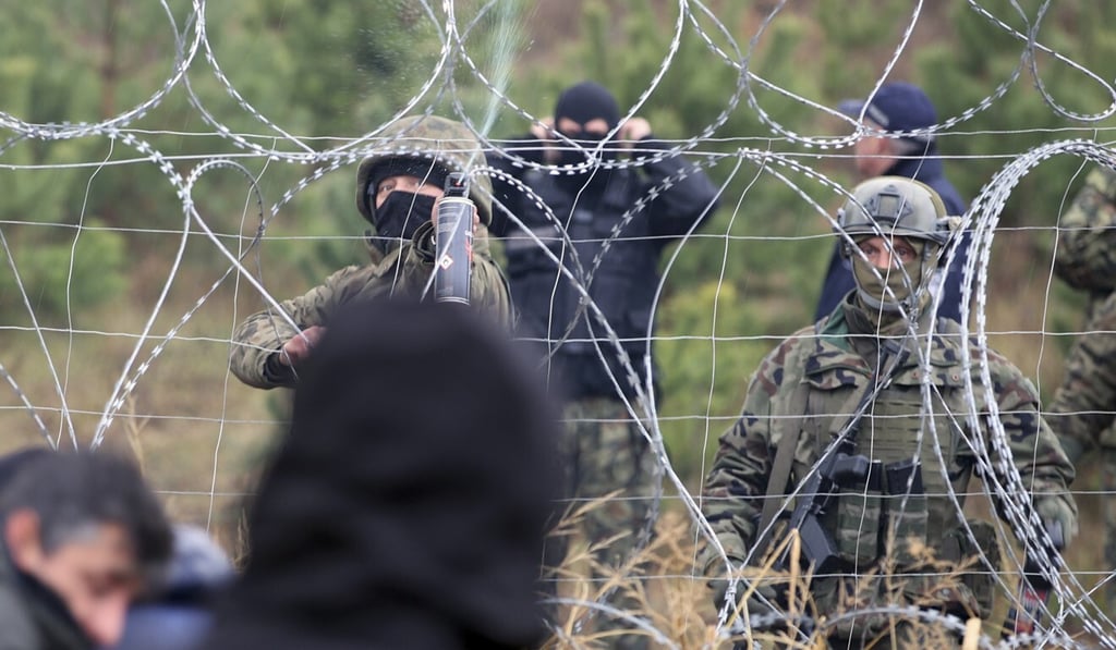 Polish border guards stand near the barbed wire as migrants from the Middle East and elsewhere gather at the Belarus-Poland border near Grodno, Belarus, on November 8.Photo: AP Polish border guards stand near the barbed wire as migrants from the Middle East and elsewhere gather at the Belarus-Poland border near Grodno, Belarus, on November 8.Photo: AP