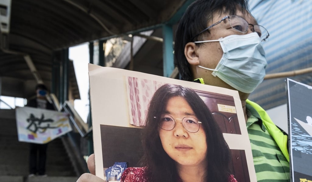 A pro-democracy activist stands near the Liaison Office of the Central People’s Government in the Hong Kong Special Administrative Region department as he holds up a signs in support of Chinese citizen journalist Zhang Zhan in Hong Kong in December last year. Photo: EPA-EFE A pro-democracy activist stands near the Liaison Office of the Central People’s Government in the Hong Kong Special Administrative Region department as he holds up a signs in support of Chinese citizen journalist Zhang Zhan in Hong Kong in December last year. Photo: EPA-EFE