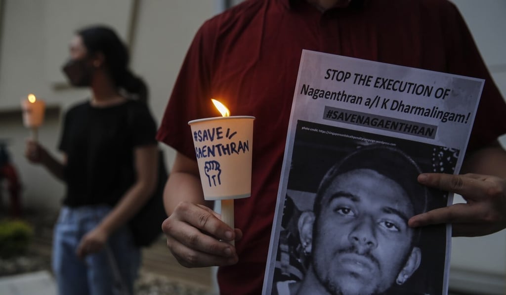 An activist with a placard featuring the picture of Nagaenthran, who was convicted of a drug offence 10 years ago in Singapore and is due to be executed. Photo: EPA