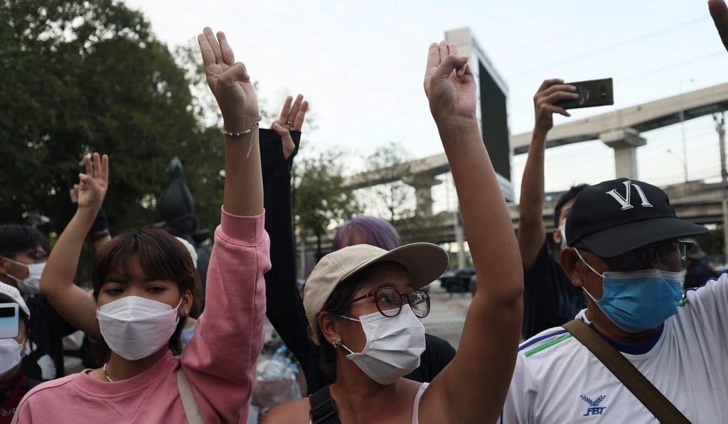 Protesters doing the three-finger pro-democracy salute outside Thailand’s Constitutional Court on November 10, after it ruled that three protesters' demands on monarchy reform amounted to calls to overthrow the monarchy. Photo: AFP