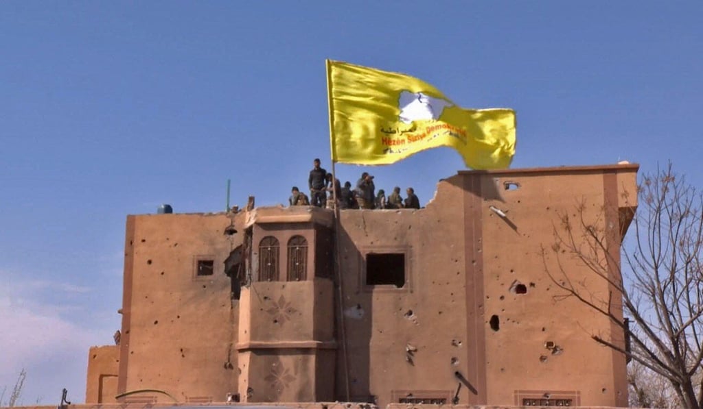 The US-backed Syrian Democratic Forces (SDF) raise their flag atop a building in Baghuz after defeating the Islamic State in March 2019. Photo: Ronahi TV via AFP The US-backed Syrian Democratic Forces (SDF) raise their flag atop a building in Baghuz after defeating the Islamic State in March 2019. Photo: Ronahi TV via AFP