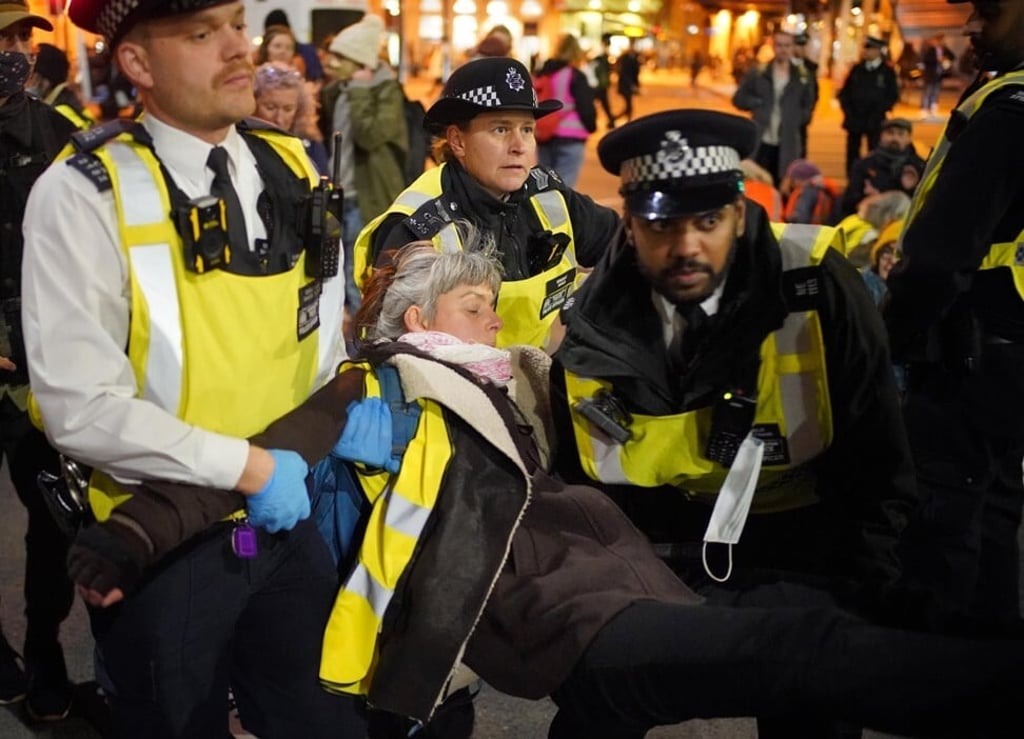 Police remove an Insulate Britain climate activist taking part in a demonstration on Vauxhall Bridge in central London on Saturday. Photo: PA Wire / DPA