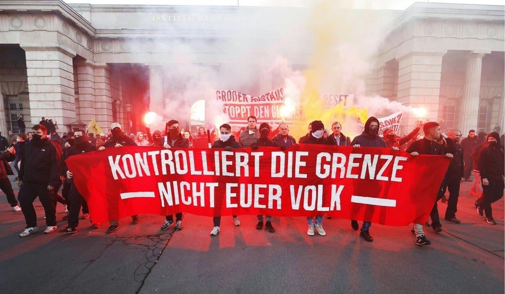 Austrians light flares while marching down the Heldenplatz during a lockdown protest. Photo: APA/dpa