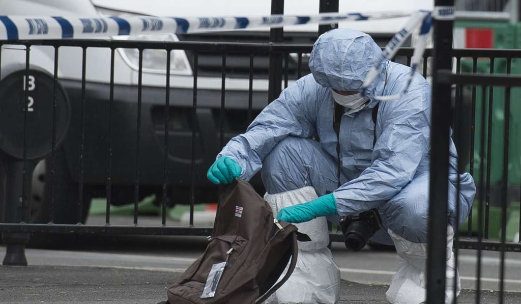 A Forensic Officer examine items left on the pavement after police lead away a man following an incident in Central London. Reports said the man detained carrying knifes. Photo: EPA